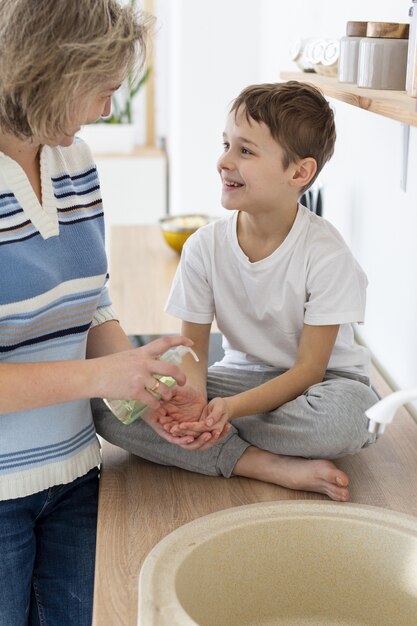 Mother helps child wash his hands