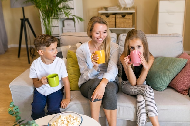 Mother and her children sitting on a couch front view