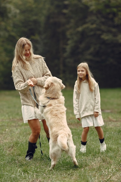 Free Photo mother and her daughter playing with dog. family in autumn park. pet, domestic animal and lifestyle concept