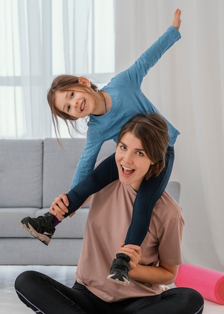 Mother holding girl on shoulders medium shot