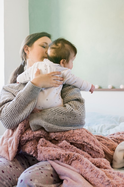 Free Photo mother hugging cute baby 