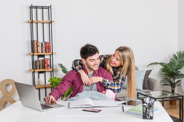 Mother hugging father with baby at desk