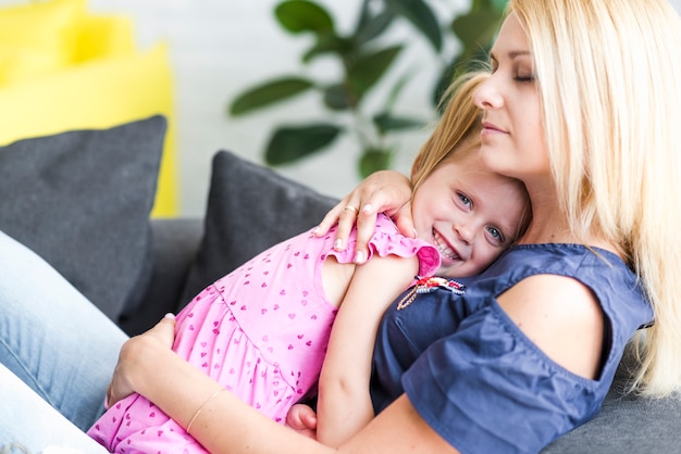 Free Photo mother hugging her smiling little daughter