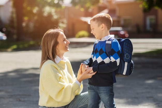 Free photo mother and kid on first school day side view