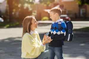 Free photo mother and kid on first school day side view