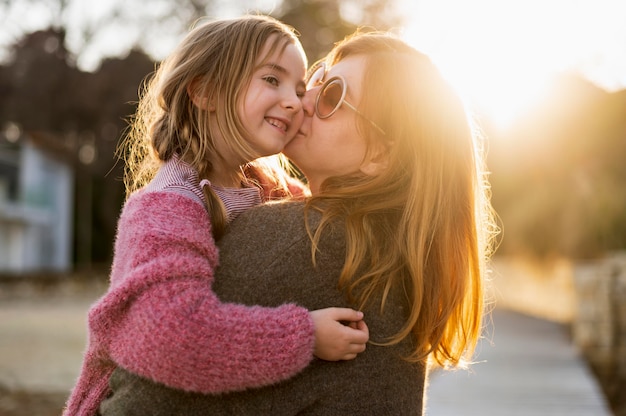 Mother kissing young girl medium shot