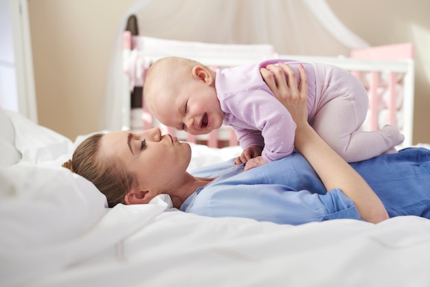 Mother lifting her pretty newborn