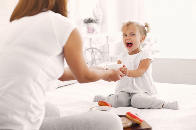 Free photo mother and little daughter have a breakfast at home