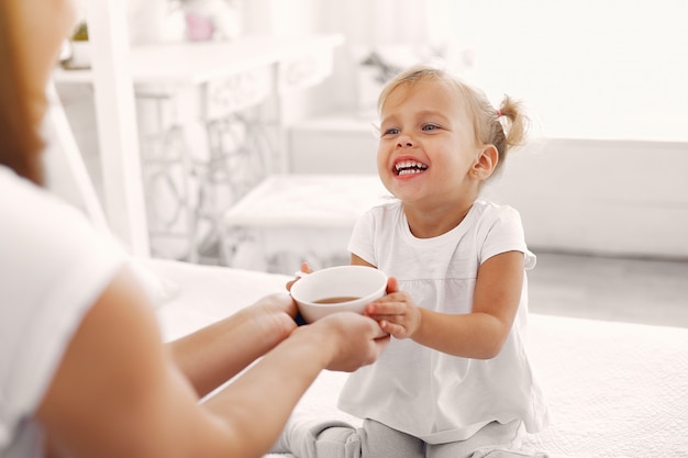 Free photo mother and little daughter have a breakfast at home