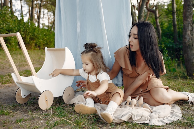 Free Photo mother and little daughter playing in a summer field