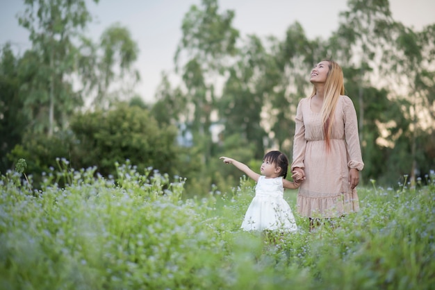 Mother and little daughter playing together in a park