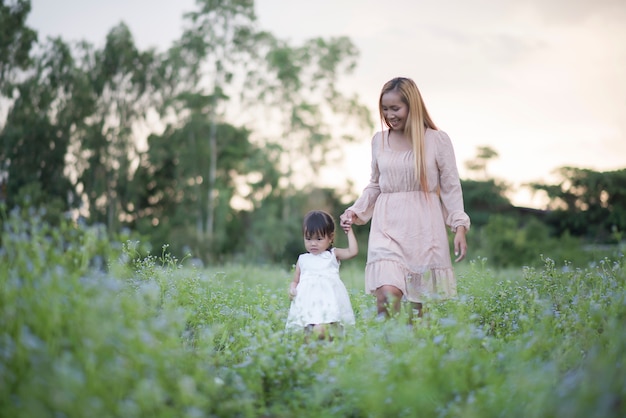 Mother and little daughter playing together in a park