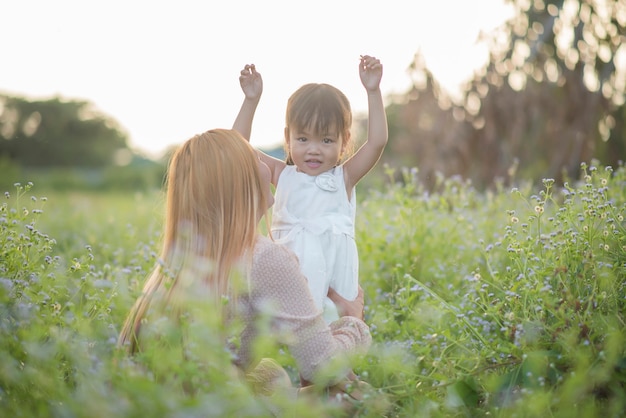 Free Photo mother and little daughter playing together in a park