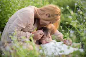 Free photo mother and little daughter playing together in a park