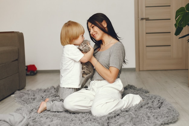 Mother and little son fun at home with a cat