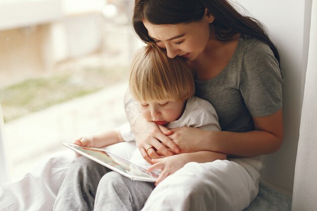 Mother and little son sitting on a windowsill