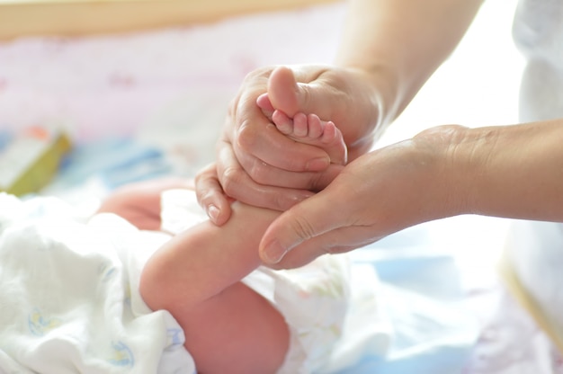 Mother massaging her child's foot, shallow focus