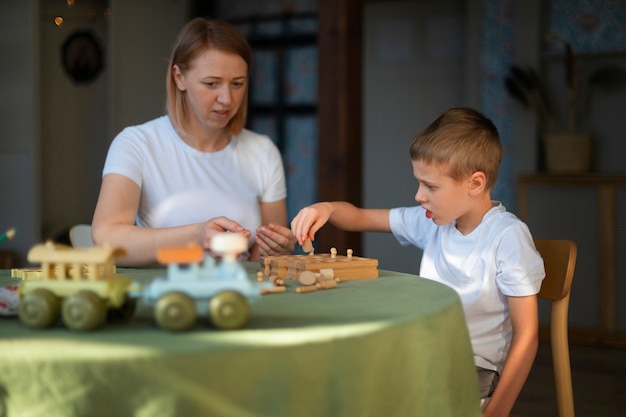 Mother playing with her autistic son using toys