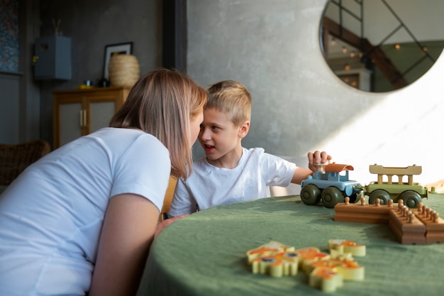 Mother playing with her autistic son using toys