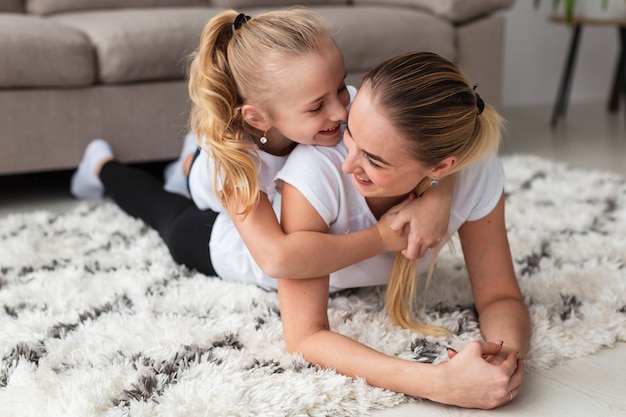 Mother posing with daughter at home