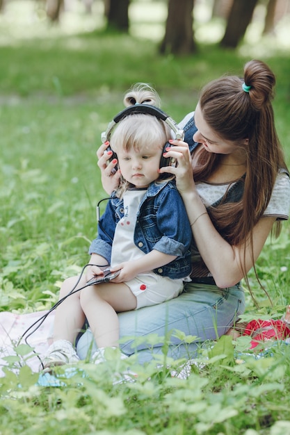 Mother putting headphones on her little daughter