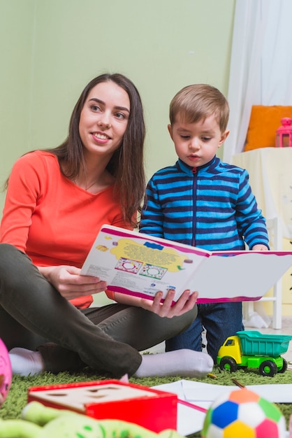 Mother reading book with son in children room