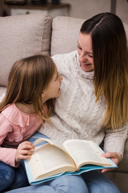 Mother reading together with daughters