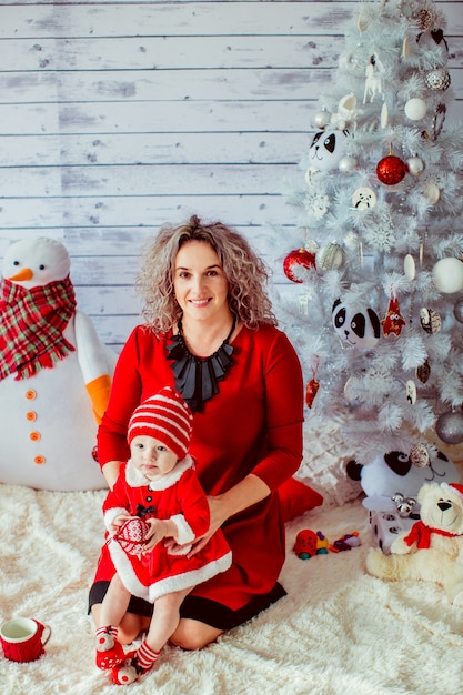 "Mother in red dress holding toddler girl"