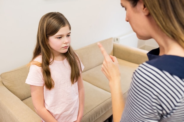 Mother scolding her daughter in living room