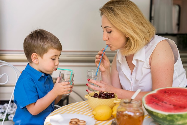 Free photo mother and son drinking lemonade