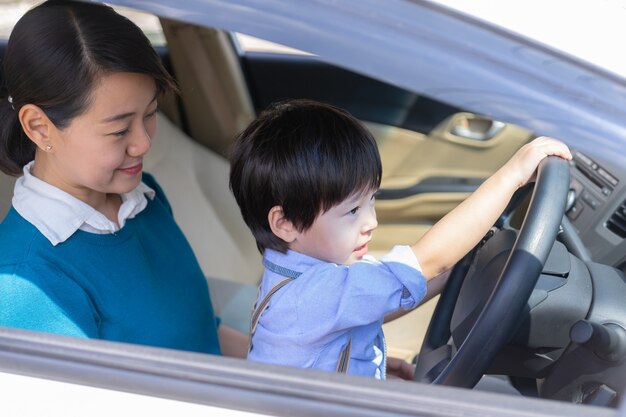 Mother and son enjoy to play with steering wheel 