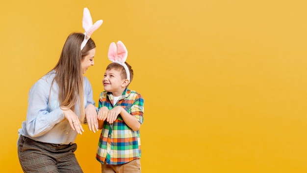 Mother and son imitating rabbit with copy-space