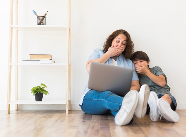 Mother and son looking on laptop