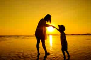 Free photo a mother and son in outdoors at sunset with copy space