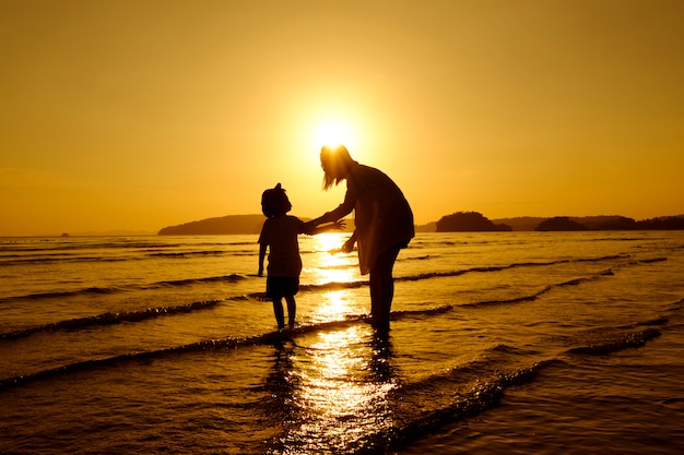 Free Photo a mother and son in outdoors at sunset with copy space