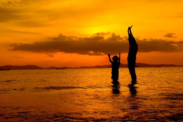 Free Photo a mother and son in outdoors at sunset with copy space