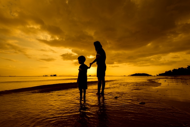 Free Photo a mother and son in outdoors at sunset with copy space