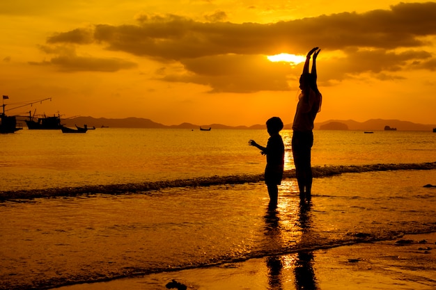 A mother and son in outdoors at sunset with copy space