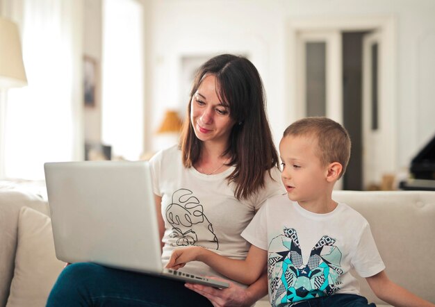 mother and son on the sofa use a laptop