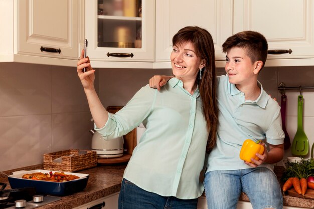 Mother and son taking selfie together with vegetable