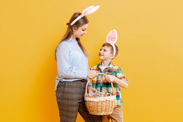 Free Photo mother and son with basket of painted eggs