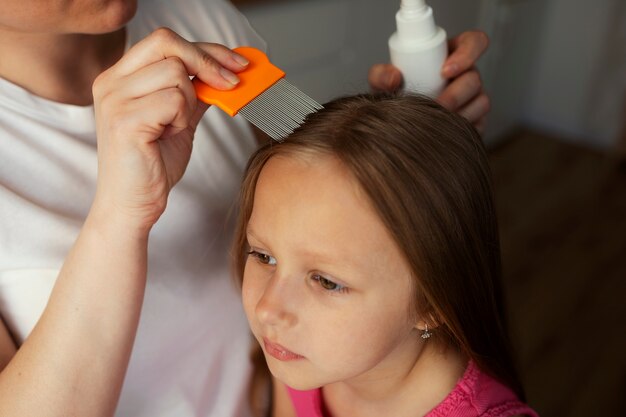 Mother taking care of child with head lices