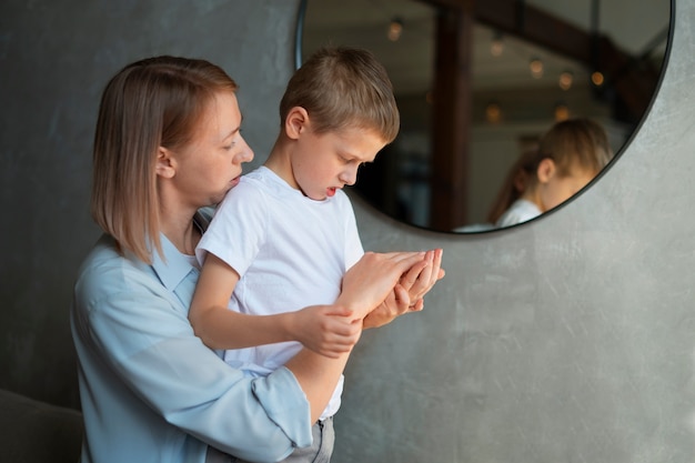 Free photo mother taking care of her autistic son at home