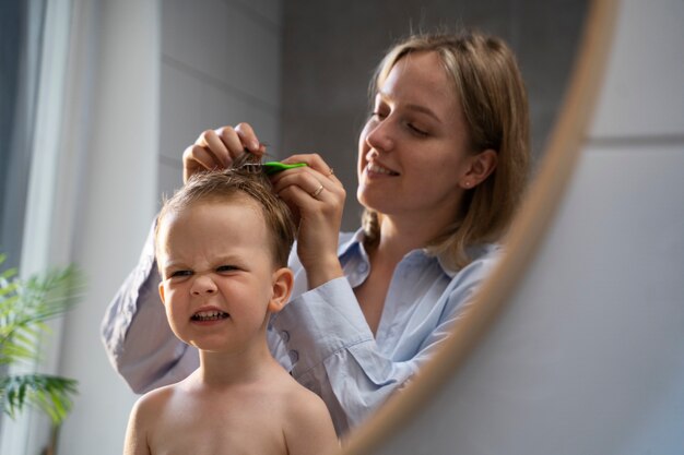 Mother taking care of her kid with lices