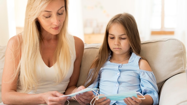 Mother teaching daughter about medical masks