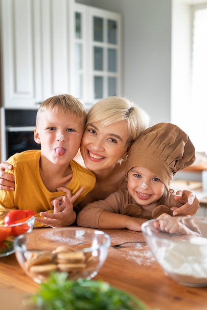 Free photo mother teaching her children to cook at home