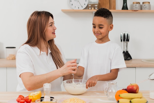 Mother teaching son to prepare food in the kitchen