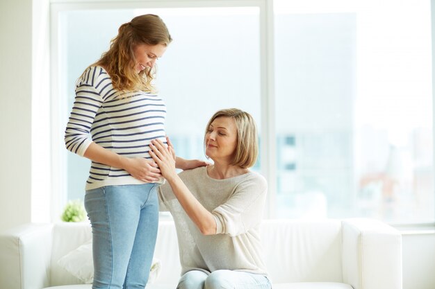 Mother touching her daughter's belly