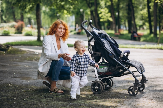 Free photo mother walking in park with her little son