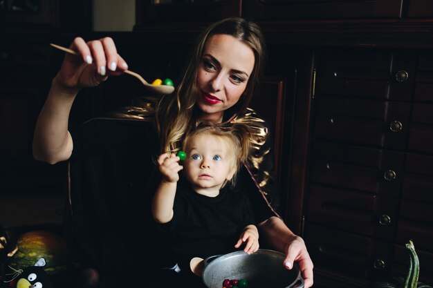 Mother with candy in a spoon while her daughter looks